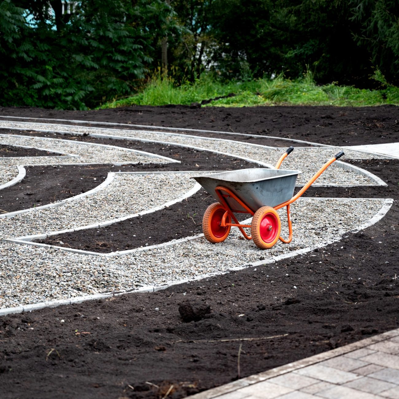 Wheelbarrow on a landscaped garden pathway..